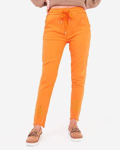 Pomarańczowe materiałowe spodnie damskie z cyrkoniami - Odzież